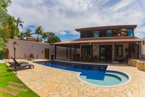 a villa with a swimming pool and a house at Solarium Da Represa in Santa Branca