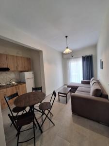 ein Wohnzimmer mit Sofa, Tisch und Stühlen in der Unterkunft Manis Central Studios in Skala Sotiros