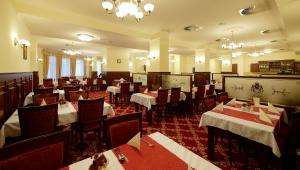 a restaurant with tables and chairs in a room at Spa hotel Čajkovskij in Karlovy Vary
