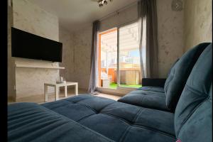 a living room with two blue beds and a television at Pasarla rico in Torreblanca