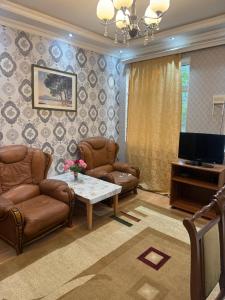 a living room with two chairs and a television at Gabala mountain house in Gabala