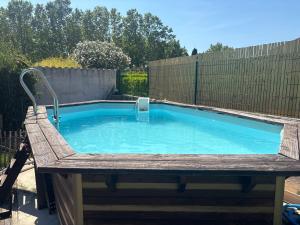 a swimming pool in a backyard with a wooden fence at Studio cosy avec accès jardin in Lunel-Viel
