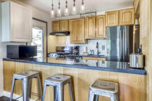 a kitchen with wooden cabinets and two bar stools at Orion Ridge Retreat in Stateline