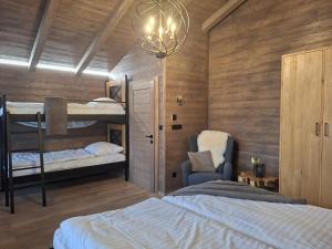 a bedroom with two bunk beds and a chandelier at Chalet Johannes in Liptovský Ján +25 photos