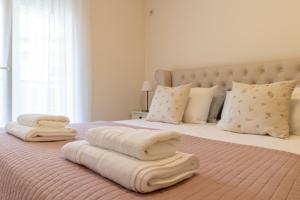 a bedroom with a bed with towels on it at Lumi Apartment in Podgorica