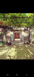 a building with a wooden door with red flowers at CASA ROTARU in 2 Mai