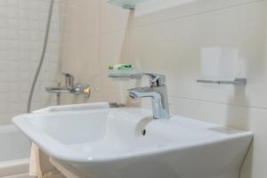 a bathroom sink with a faucet and a mirror at Lumi Apartment in Podgorica +31 photos