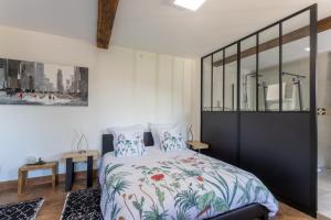 a bedroom with a large bed with a floral bedspread at Domaine Cherps Spa - Sérénité in Vielleségure