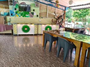 a restaurant with tables and chairs and a wall with paintings at Sree Durga Veerabhoomi Resort in Kushālnagar