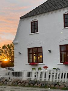 a white house with a white fence and windows at Humble Kro og Hotel in Humble
