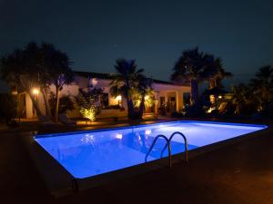 a swimming pool in front of a house at night at Quinta das Amendoeiras B&B in Nora