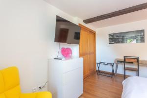 a bedroom with a bed and a yellow chair at Domaine Cherps Spa - Zen in Vielleségure