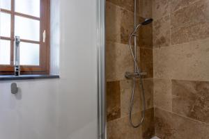 a shower with a shower head in a bathroom at Domaine Cherps Spa - Zen in Vielleségure