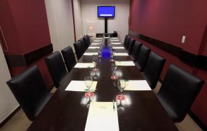 a long table with chairs and wine glasses on it at Hotel y Casino Del Río - General Roca in General Roca