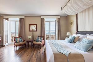 ein Hotelzimmer mit einem großen Bett und Fenstern in der Unterkunft Rock Hotel in Gibraltar