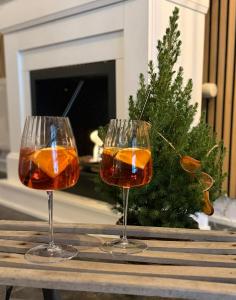 two wine glasses on a wooden table with a christmas tree at Humble Kro og Hotel in Humble