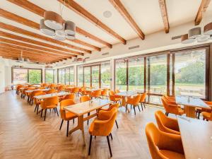 a dining room with tables and chairs and windows at Hotel Sachsengang - free parking, near U1 & U2 in Groß-Enzersdorf