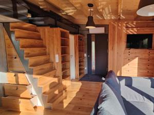 ein Zimmer mit Holztreppe in einem Haus in der Unterkunft Spektakuläres Tiny House im Teich mit Terrasse und Kamin in Großharthau