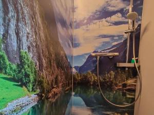 ein Badezimmer mit einem Gemälde eines Wasserfalls in der Unterkunft Spektakuläres Tiny House im Teich mit Terrasse und Kamin in Großharthau + 19 Fotos