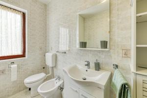 a bathroom with a sink and a toilet and a mirror at Apartman Maria Pia in Lovran +8 photos