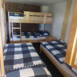 two bunk beds with blue and white checkered sheets at Chata Jeřabina in Klíny