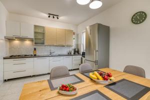 a kitchen with a table with a bowl of fruit on it at Apartman Maria Pia in Lovran