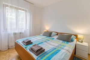 a bedroom with a large bed with towels on it at Apartman Maria Pia in Lovran