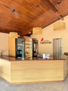 a restaurant with a counter with a drink station at Hotel Uirapuru in Goianesia do Para