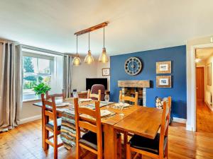 a dining room with a wooden table and a blue wall at 2 Bed in Morpeth oc-cn049 in Acklington +17 photos