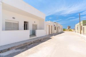 an empty street next to a white building at Baia Di Torre Squillace in Sant'Isidoro
