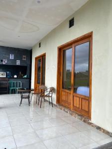 a patio with a wooden door and chairs and a table at Sabin view homestay in Licin