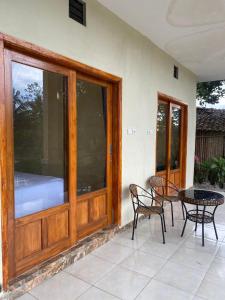 a patio with a table and chairs and a glass door at Sabin view homestay in Licin