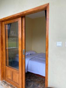 a glass door leading into a bedroom with a bed at Sabin view homestay in Licin +1 photo