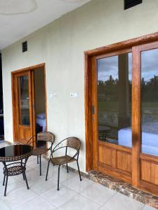 a patio with a table and chairs and a glass door at Sabin view homestay in Licin