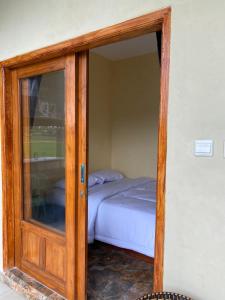 a glass door leading into a bedroom with a bed at Sabin view homestay in Licin