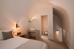 a bedroom with a bed and a bathroom with a sink at Santorini - Villa - Sleeps 4 - Pool - Parking in Mesaria +16 photos