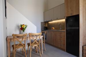 a kitchen with a wooden table and two chairs at Santorini - Villa - Sleeps 4 - Pool - Parking in Mesaria