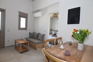 a living room with a table and a couch at Santorini - Villa - Sleeps 4 - Pool - Parking in Mesaria