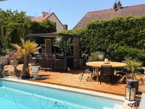 a patio with a table next to a pool at L'ESCALE Chambres et table d'hôtes in Verdun-sur-le-Doubs