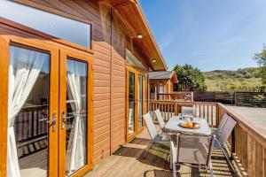 a wooden deck with a table and chairs on it at 2 Bed in Okehampton oc-80373 in Okehampton