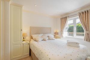 a bedroom with a bed with white sheets and a window at 2 Bed in Okehampton oc-80373 in Okehampton