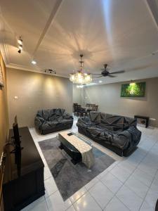 a living room with two couches and a chandelier at Kapar Cozy Homestay in Kapar