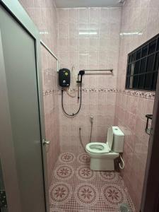 a pink bathroom with a toilet and a shower at Kapar Cozy Homestay in Kapar