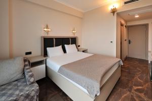 a bedroom with a large bed and a couch at Asil Luxury Boutique in Burhaniye