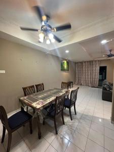 a dining room with a ceiling fan and a table and chairs at Kapar Cozy Homestay in Kapar