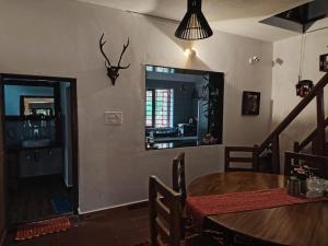 a dining room with a table and a mirror at Reevilla in Madikeri