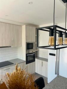 a kitchen with white cabinets and a stove top oven at Casa Rosarinho in Faro