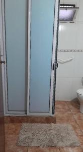 a bathroom with a door with a rug and a toilet at Iguazú Cabañas in Puerto Iguazú +30 photos