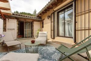 a patio with a table and chairs on a porch at Le Mas de la Rode in Saumane