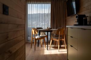 a table and chairs in a kitchen with a window at Nordlys Retreat in Teşila
